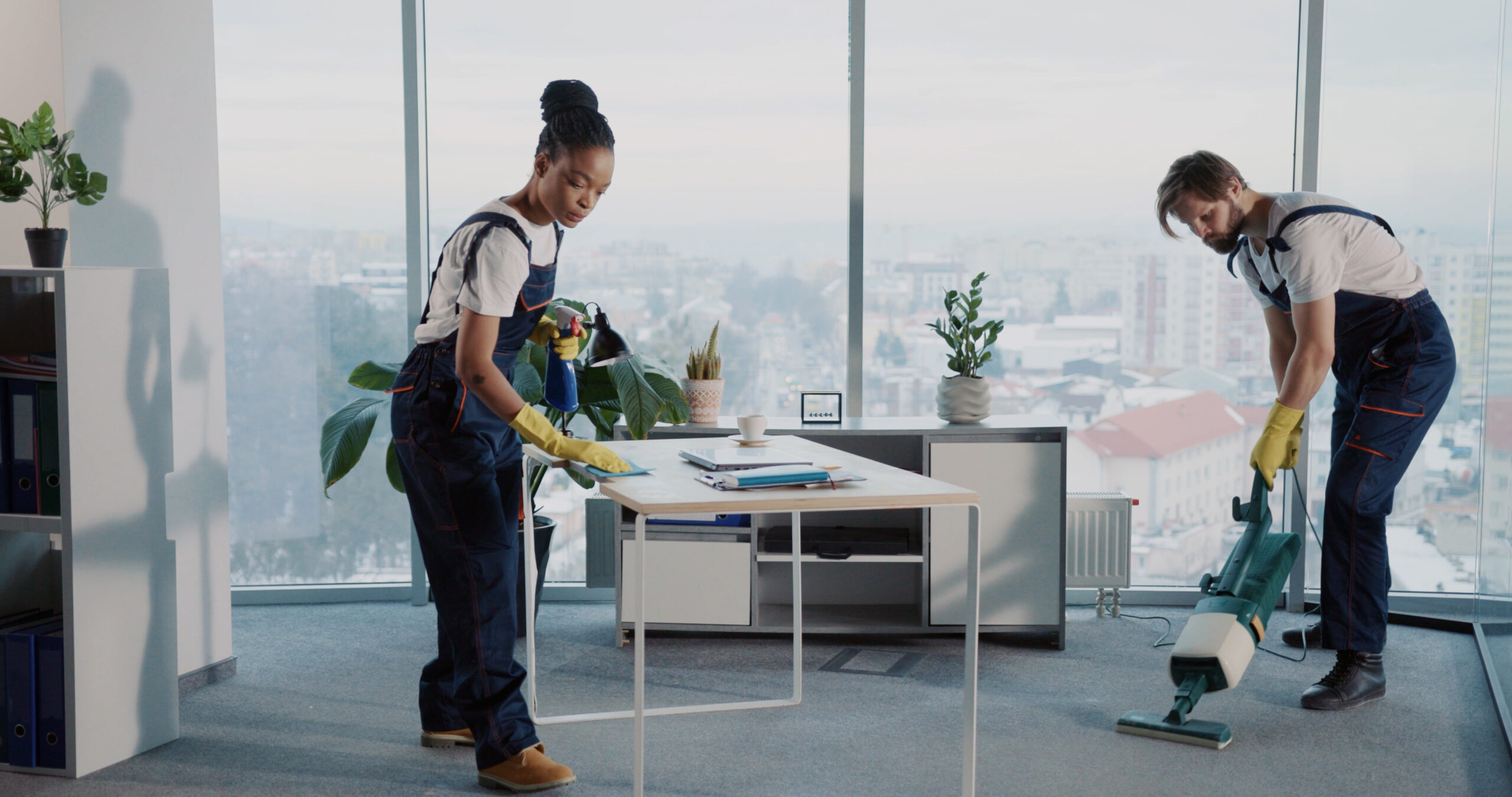 Janitor team of multi-ethnic people cleaning corporate office company room. Young caucasian manin uniform using vacuum cleaner. Choisir le Service de Nettoyage Commercial Idéal